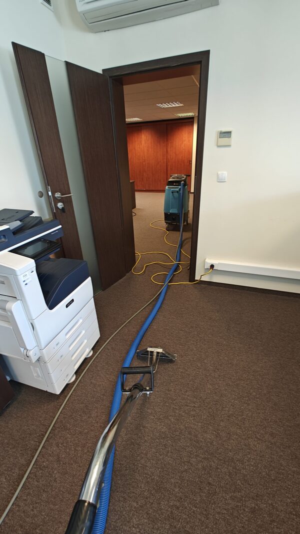 sprzątanie pokoju biurowego niebieskim odkurzaczem piorącym